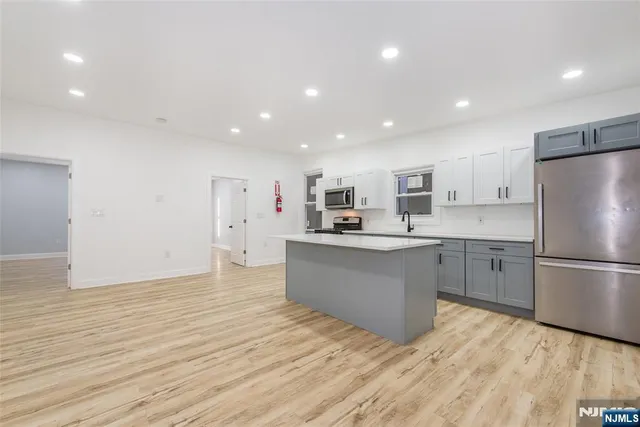 a kitchen with a refrigerator and a stove top oven