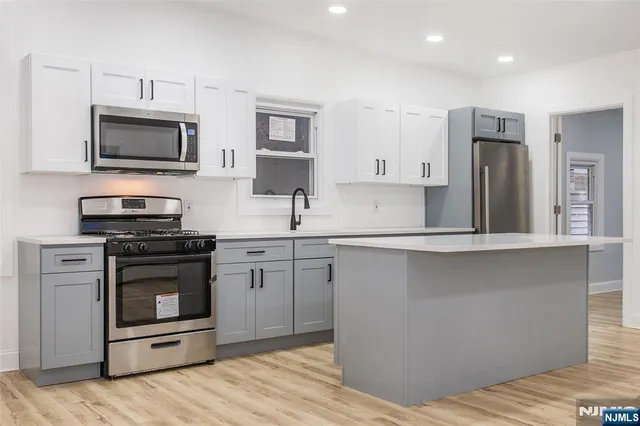 a kitchen with stainless steel appliances a stove microwave and sink