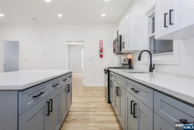 a kitchen with granite countertop a sink and cabinets