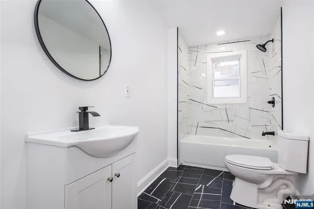 a bathroom with a sink a toilet and a mirror