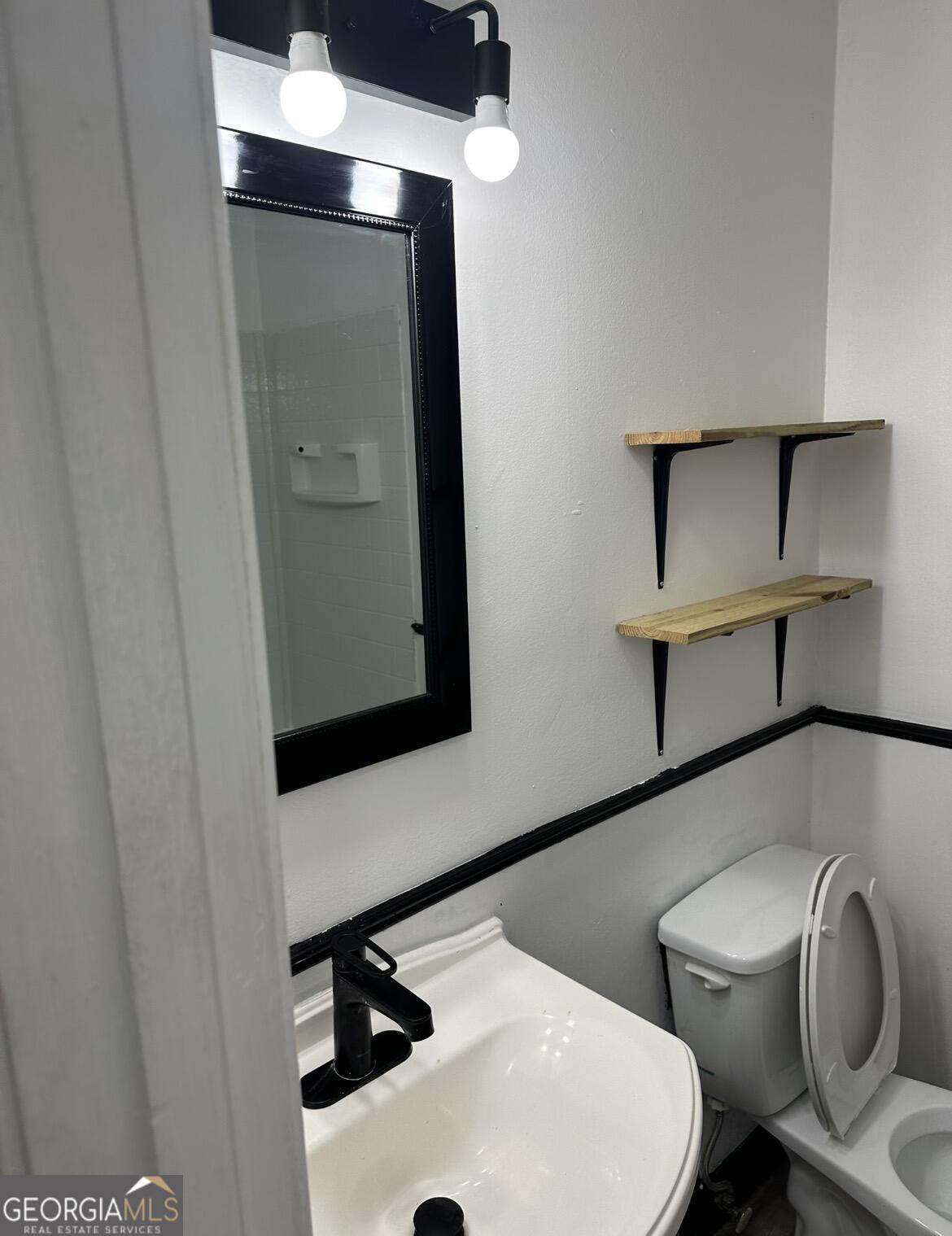 2725 Flintlock Place Austell, GA 30106 - Photo 15 of 28 a bathroom with a toilet a sink and mirror