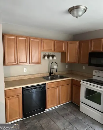 a kitchen with stainless steel appliances granite countertop a sink a stove top oven a counter space and cabinets
