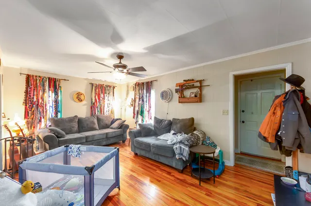 a living room with furniture and wooden floor