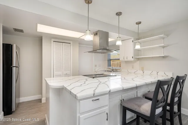 a kitchen with a table a sink cabinets and stainless steel appliances