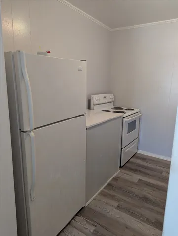 a utility room with wooden floor washer and dryer