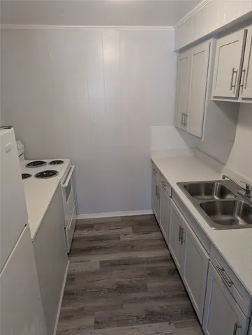 a kitchen with granite countertop a sink and a stove top oven