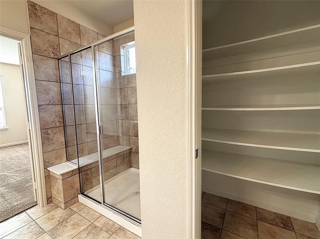 9435 Smoke Tree Drive Forney, TX 75126 - Photo 17 of 36 a bathroom with a shower and a glass door