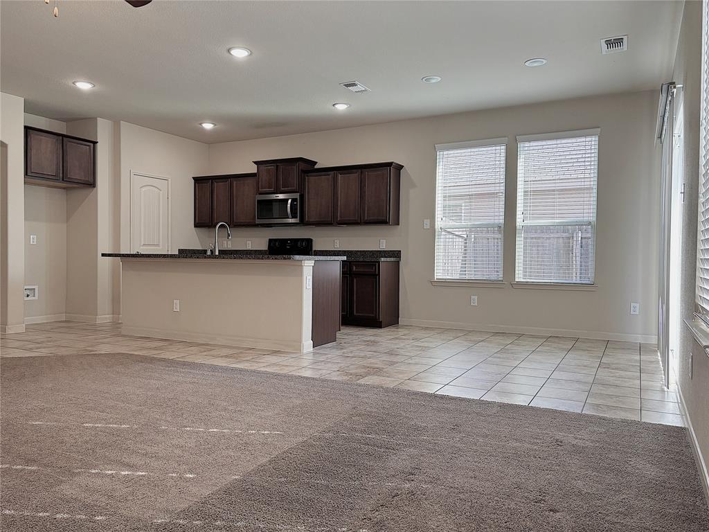 9435 Smoke Tree Drive Forney, TX 75126 - Photo 4 of 36 a kitchen with stainless steel appliances granite countertop a stove top oven a sink a microwave and a refrigerator