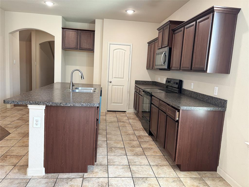 9435 Smoke Tree Drive Forney, TX 75126 - Photo 6 of 36 a kitchen with stainless steel appliances granite countertop a refrigerator and a stove