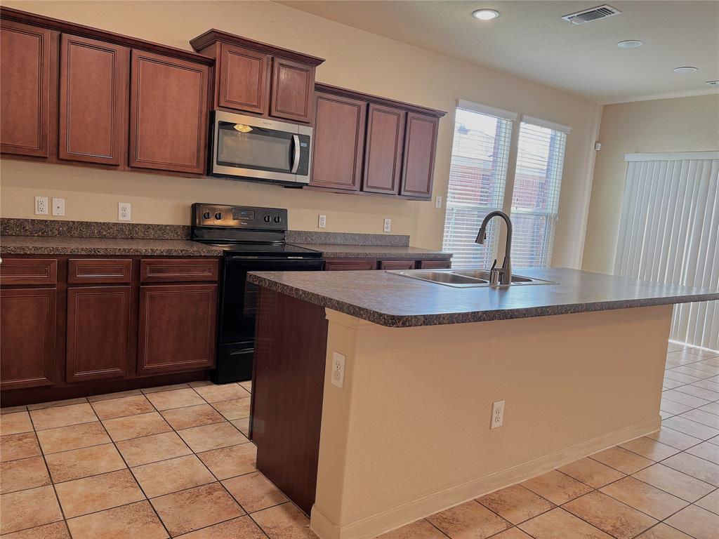 9435 Smoke Tree Drive Forney, TX 75126 - Photo 8 of 36 a kitchen with kitchen island granite countertop a stove top oven microwave and cabinets