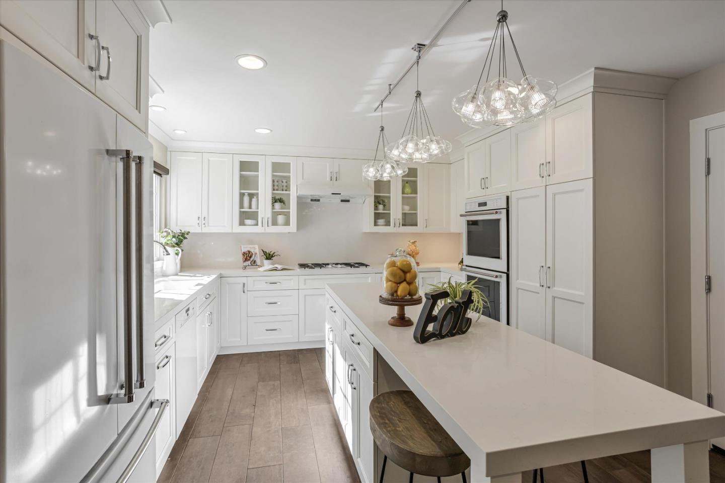 1716 Grizilo Drive San Jose, CA 95124 - Photo 11 of 49 a kitchen that has a lot of white cabinets a sink dishwasher and a dining table with wooden floor