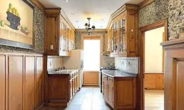 a kitchen with stainless steel appliances granite countertop a refrigerator a sink dishwasher and wooden cabinets with wooden floor