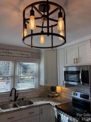 a kitchen with stainless steel appliances a stove a sink and a microwave