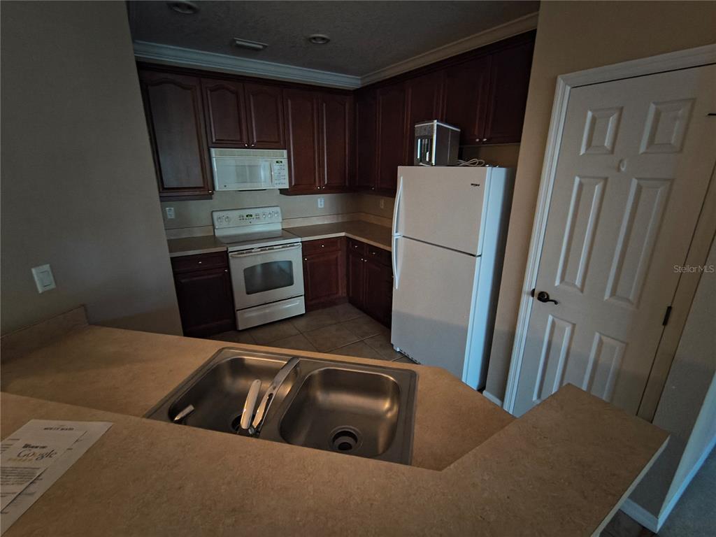 11446 Jasper Kay Terrace, Unit 1009 Windermere, FL 34786 - Photo 5 of 15 a kitchen with refrigerator and microwave