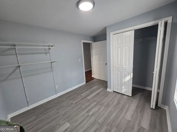 an empty room with wooden floor and closet