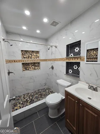 a bathroom with a toilet sink and mirror