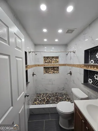 a bathroom with a sink toilet and shower