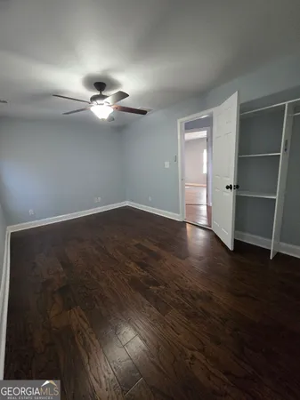 a view of a room with wooden floor and ceiling fan