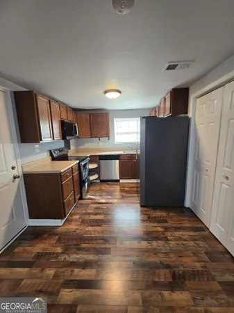 a kitchen with stainless steel appliances granite countertop a refrigerator stove top oven and sink