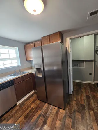 a kitchen with granite countertop a refrigerator and a sink