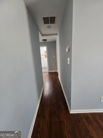 a view of a hallway with wooden floor