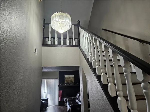 a view of a hallway to a room with furniture and wooden floor