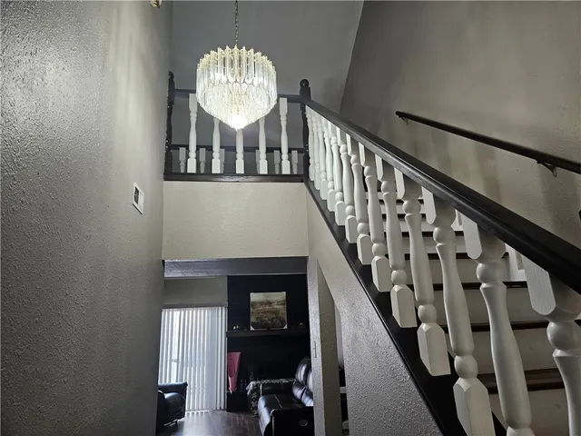 a view of a hallway to a room with furniture and wooden floor