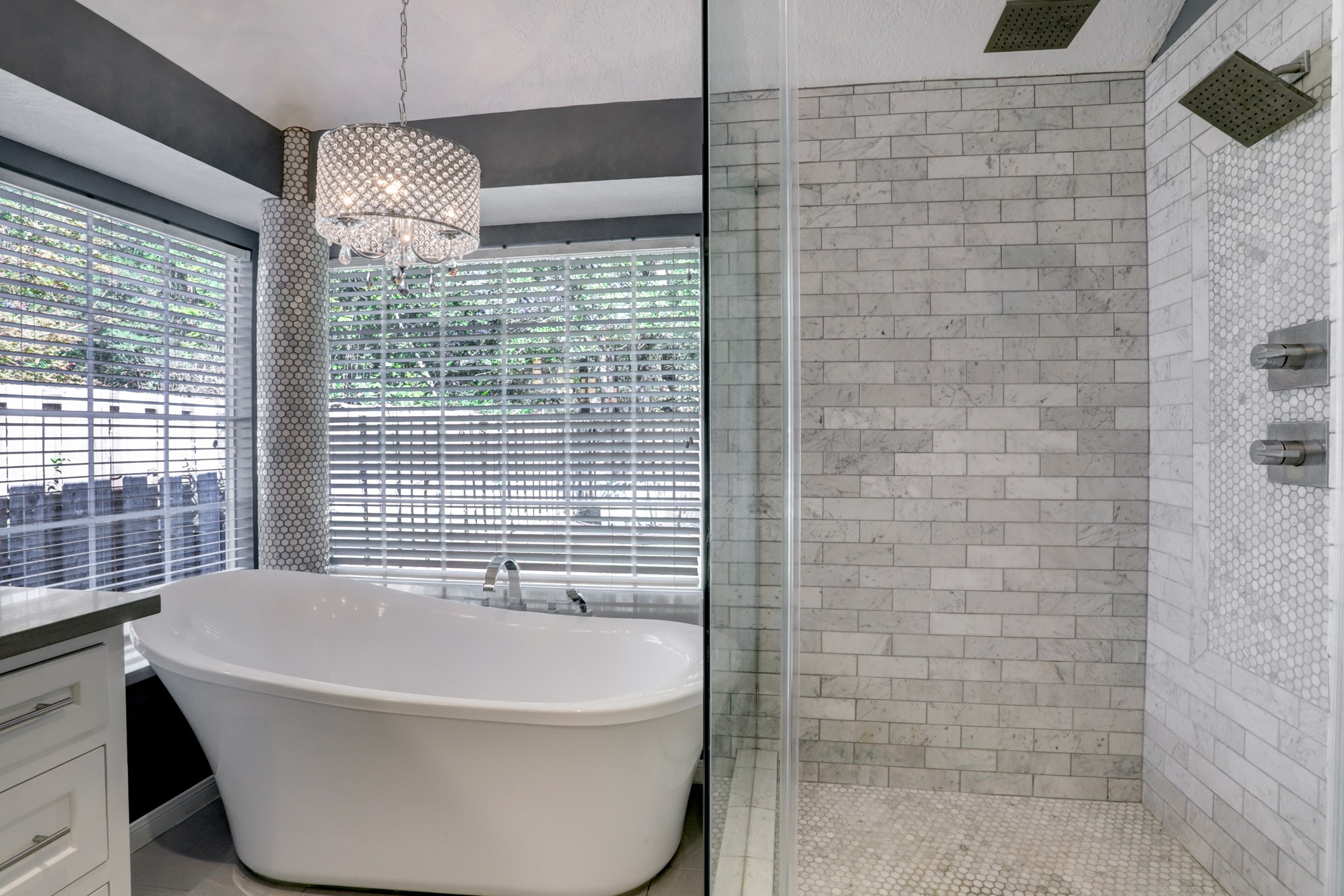138 Summer Storm Place Spring, TX 77381 - Photo 15 of 20 The spa-inspired primary bath pairs a freestanding tub with a marble-tile shower and rain showerhead.