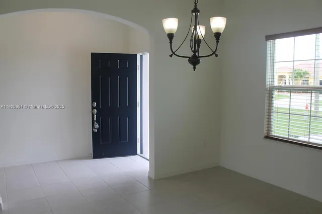 a view of hallway with windows and chandelier
