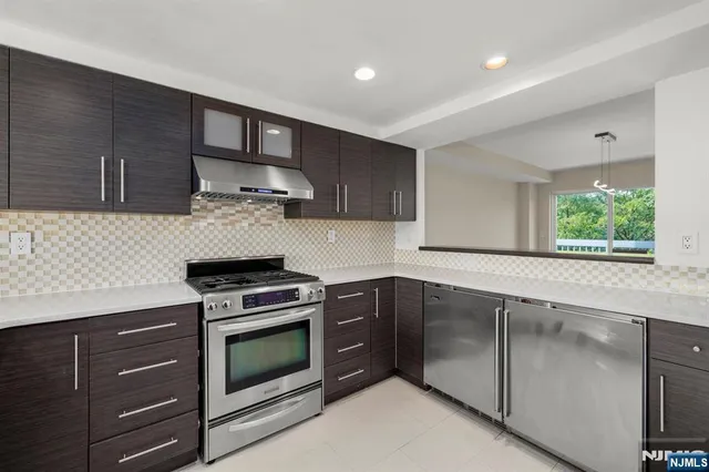 a kitchen with granite countertop wooden cabinets and stainless steel appliances