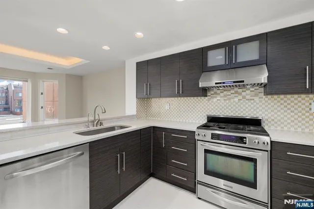 a kitchen with a sink stove top oven and cabinets