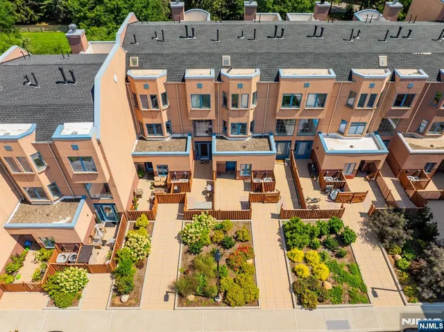 an aerial view of residential houses with outdoor space and parking