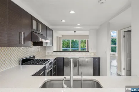 a kitchen with stainless steel appliances granite countertop a stove and a refrigerator