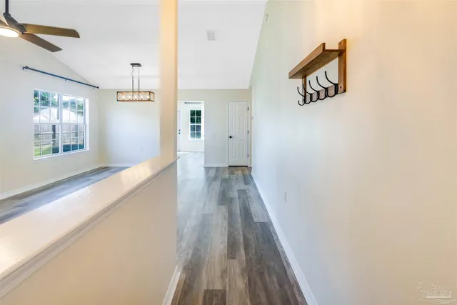 a view of a hallway with wooden floor and staircase
