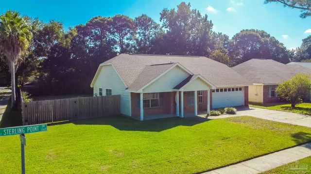 a view of a house with a backyard and a tree