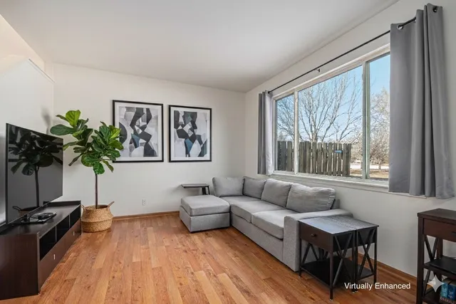 a living room with furniture and a large window with wooden floor
