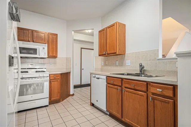 a kitchen with stainless steel appliances granite countertop a sink stove and microwave