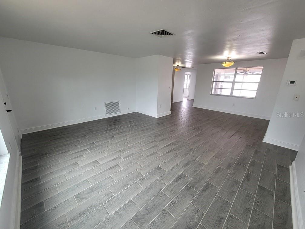 7730 Wicklow Street New Port Richey, FL 34653 - Photo 3 of 19 an empty room with wooden floor and windows
