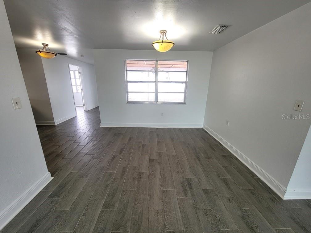 7730 Wicklow Street New Port Richey, FL 34653 - Photo 4 of 19 an empty room with wooden floor and windows