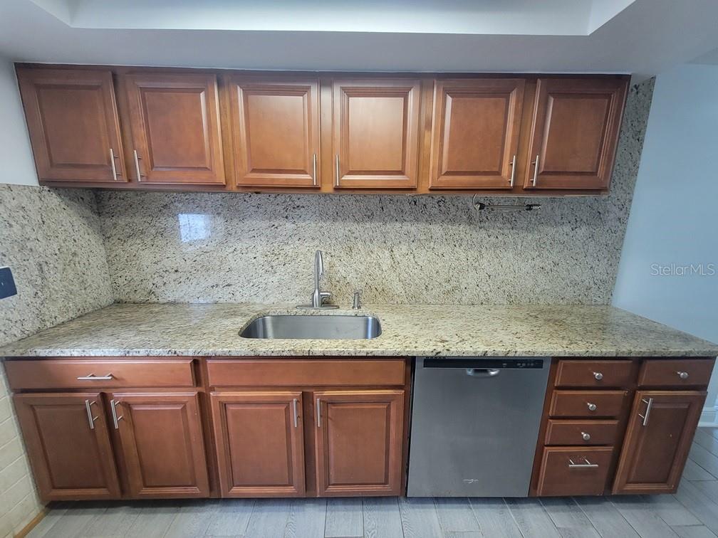 7730 Wicklow Street New Port Richey, FL 34653 - Photo 9 of 19 a kitchen with granite countertop cabinets and white appliances