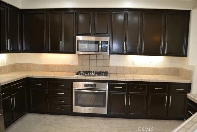 a kitchen with granite countertop stainless steel appliances and cabinets