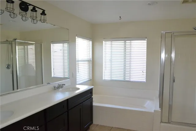 a bathroom with a granite countertop sink and a bathtub