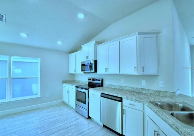 a large bathroom with a granite countertop sink and a large mirror