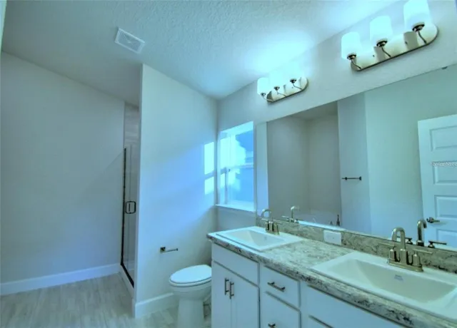 a bathroom with a granite countertop sink toilet and shower