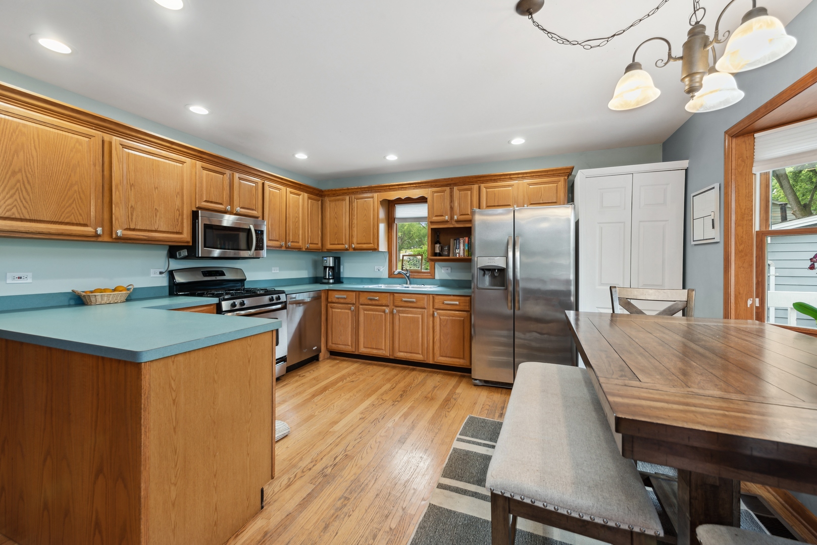 908 Pershing Drive Wauconda, IL 60084 - Photo 5 of 38 a kitchen with stainless steel appliances a refrigerator a stove a sink dishwasher a dining table and chairs with wooden floor