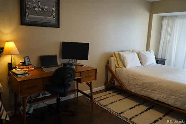 a bedroom with a bed and a desk