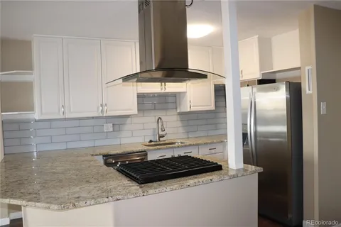 a kitchen with granite countertop a sink stainless steel appliances and cabinets