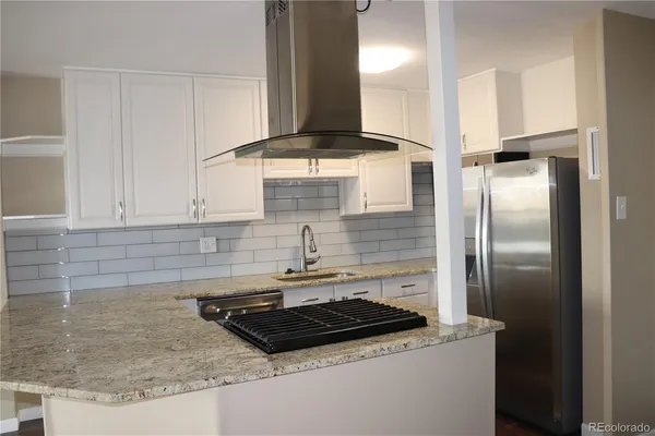 a kitchen with granite countertop a sink stainless steel appliances and cabinets