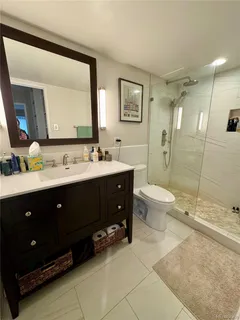 a spacious bathroom with a double vanity sink toilet mirror and shower