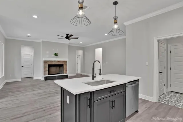 a kitchen with stainless steel appliances granite countertop a sink a stove a refrigerator and island with wooden floor